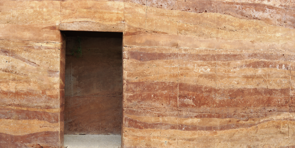 Photo of a wall constructed of layers of rammed earth.